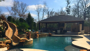 Creekstone Outdoor Living Full Outdoor Space with cabana, pool and stone slide